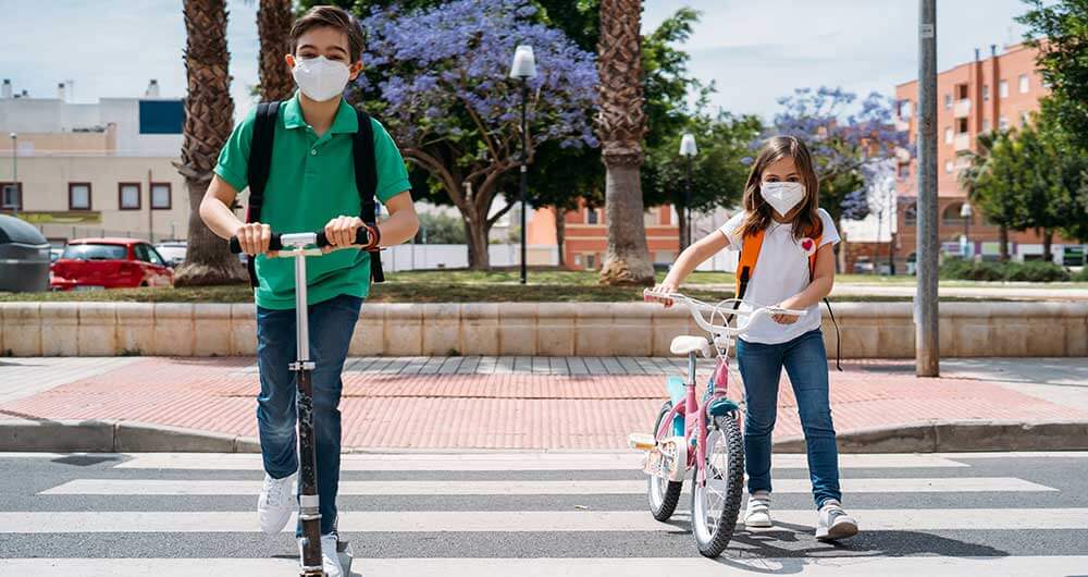 Ni�os cruzando la calle con cubrebocas