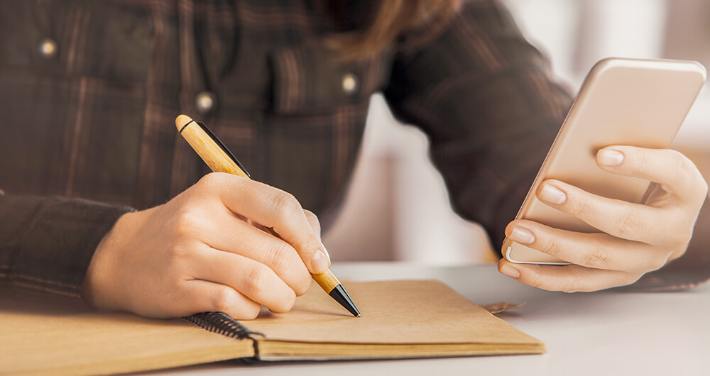 Mujer escribiendo lista de comercios para comprar comida