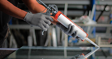 Persona aplicando silicn sobre panel de acrlico
