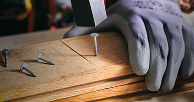 Persona fijando madera con clavos