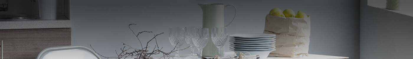 mesa de comedor con vajilla, frutas y copas de vidrio