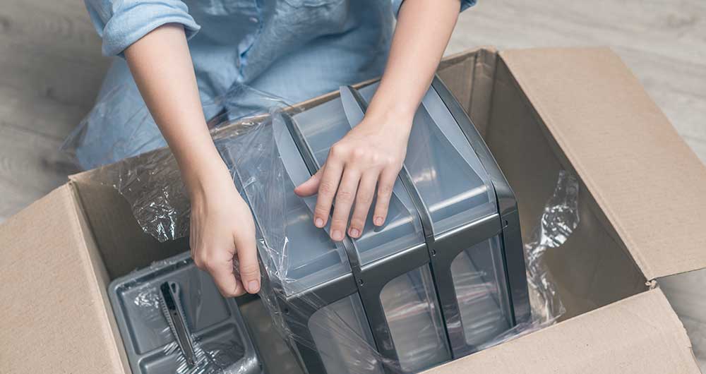 Persona sacando un producto de una caja de cart�n