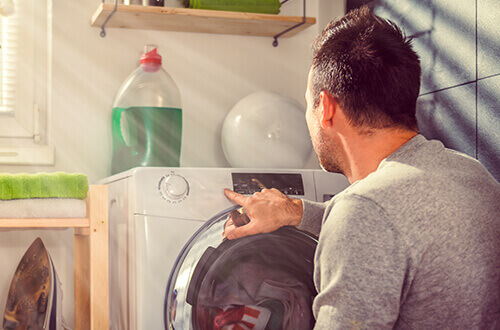Persona introduciendo rdenes a la lavadora para su uso